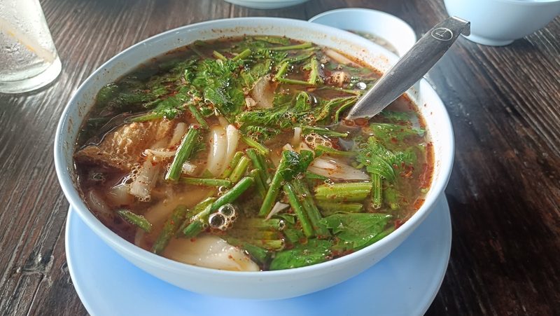 ปลาม้าจื๊อน้ำในชาม น้ำแกงสีส้มอ่อน มีหัวหอมและผักใบเขียว